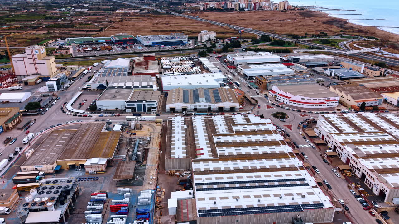 Madrid, Spain, 8 August 2025: Detailed aerial view of warehouse rooftops and industrial facilities. High angle view focusing on industrial buildings, solar panels, and outdoor storage areas