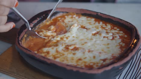 comiendo pasta al horno con queso