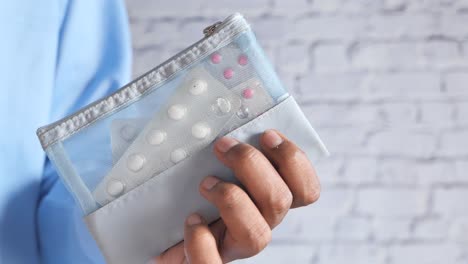 person holding a mesh bag of pills and tablets