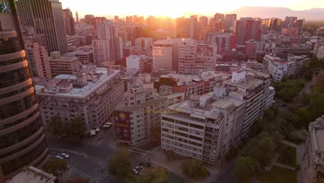 Aerial-rise-view-of-big-developed-downtown-full-of-buildings-at-sunset