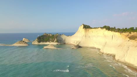 Scenic-Corfu-eroded-cliff-headland-leads-into-Ionian-turquoise-sea-AERIAL-4K