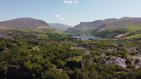 Dorothea-Cantera-Minera-De-Pizarra-Cubierta-De-Maleza-En-Desuso-En-Una-Densa-Y-Exuberante-Vista-Aérea-Del-Paisaje-Boscoso-Montañoso-De-Snowdonia