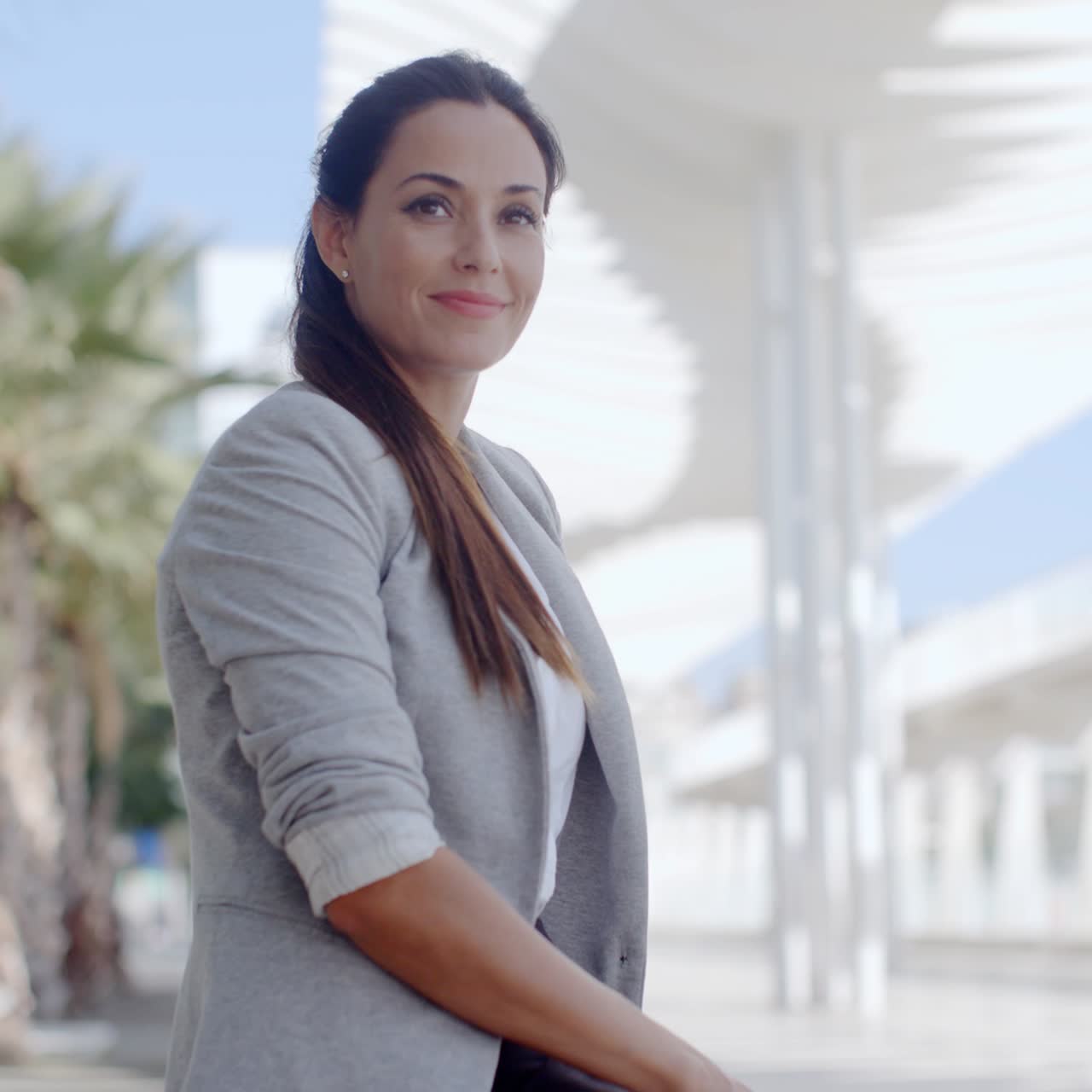 mujer elegante sentada en un banco en un paseo marítimo