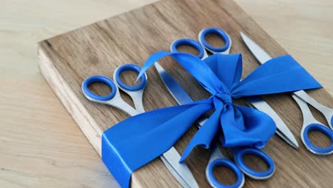 gift-wrapped scissors on wooden cutting board