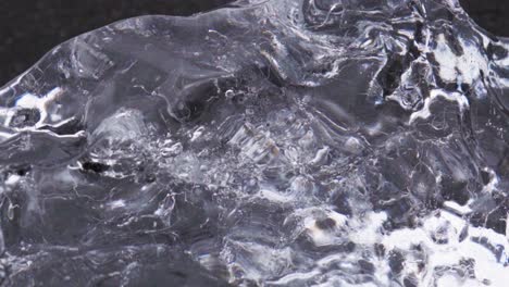 close-up details of a chunk of ice on a black sand beach in iceland -slow motion