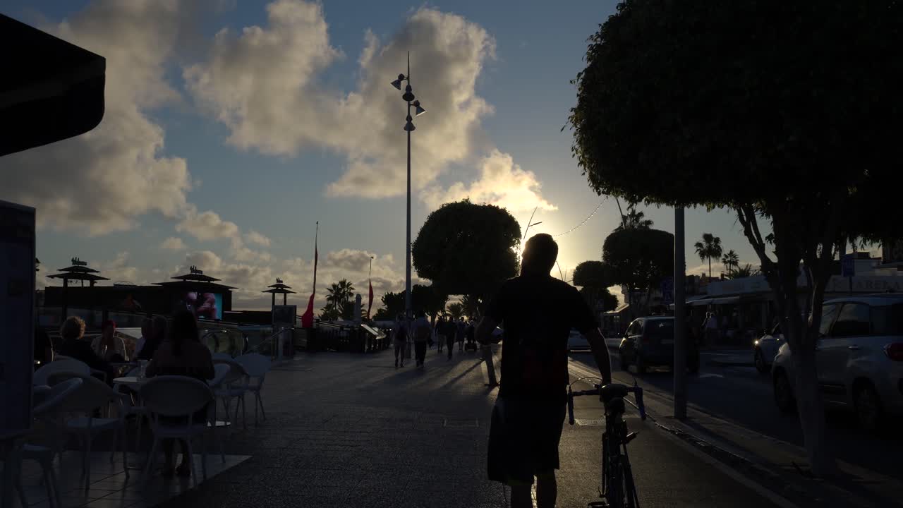 자전거 타는 사람 들 과 보행자 들 과 함께 해가 지는 도시 거리 장면