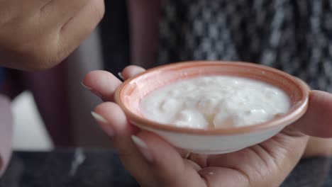 mujer comiendo un plato de yogur