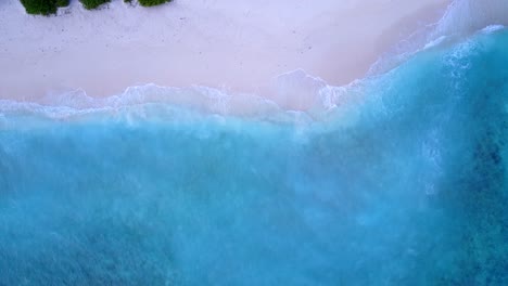 Azure-sea-with-white-waves-splashing-over-pink-sand-of-exotic-beach,-on-a-beautiful-texture-from-paradise-island-in-Bermuda