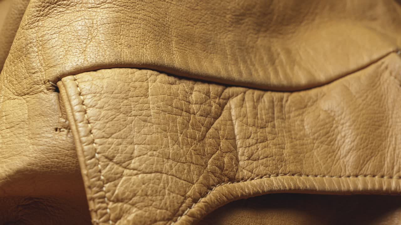 Machine stitched pocket seams on brown leather stylish jacket CLOSE-UP