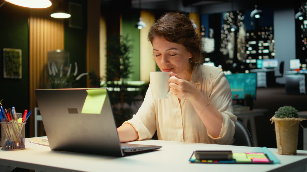 Vertical Video Businesswoman enjoying fresh cup of coffee while working late