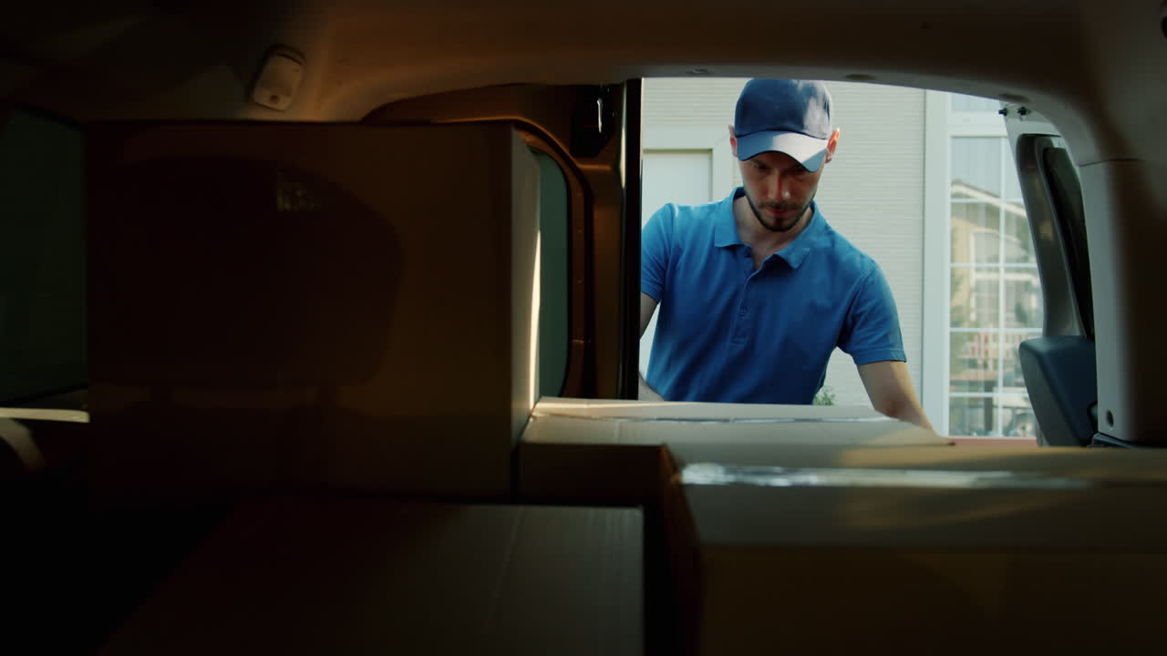 Delivery Person Loading Boxes into Car Trunk