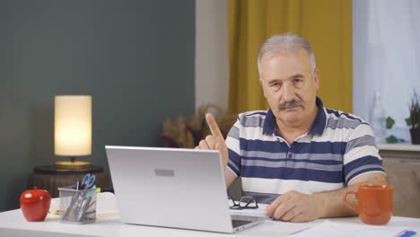 Home-office-worker-old-man-looking-at-camera-with-a-stern-angry-warning.