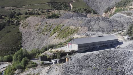 Aerial-drone-shot-over-a-mining-quarry-factory-beside-lago-Cantera-in-Spain-on-a-bright-sunny-day