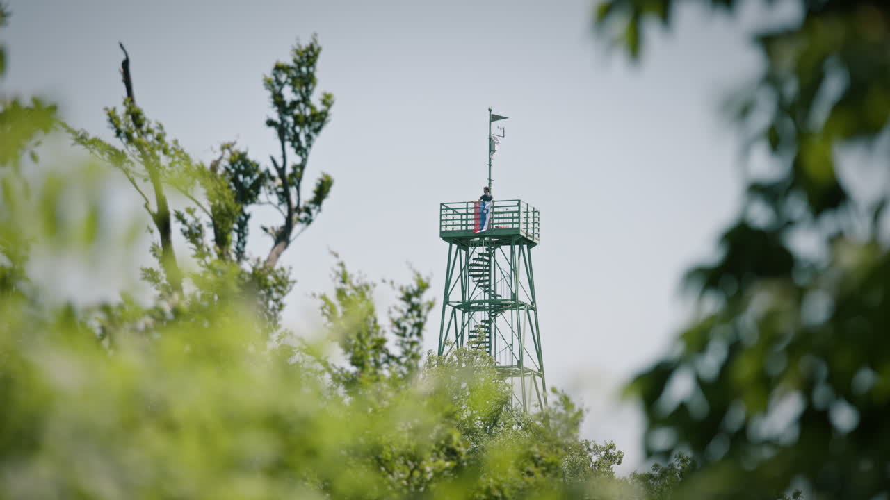 슬로베니아 국기와 탑 ot 전망대에 남자