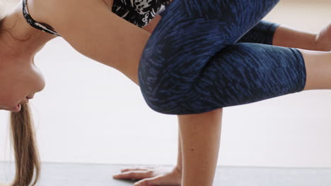 hermosa mujer de yoga ejercitando un estilo de vida saludable practicando la pose del cuervo disfrutando del entrenamiento en el estudio entrenamiento ejercicio de respiración estiramiento del cuerpo flexible