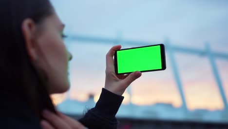 mujer tomando una foto selfie en un teléfono inteligente con pantalla verde. teléfono móvil