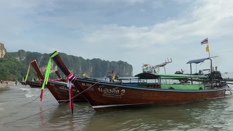 colorful long tail boats gently sway near a beach in krabi thailand