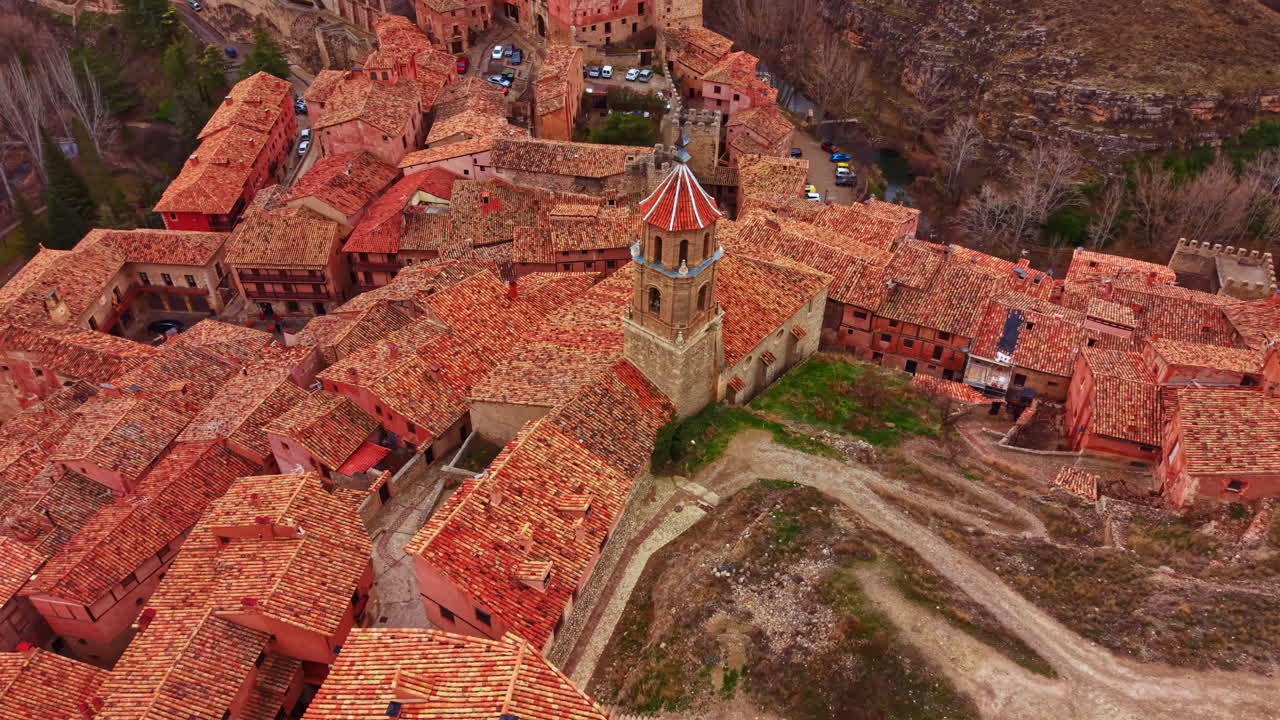 Vista de tejados rojos y edificios antiguos en un pequeño pueblo situado en una ladera en España durante un día soleado.