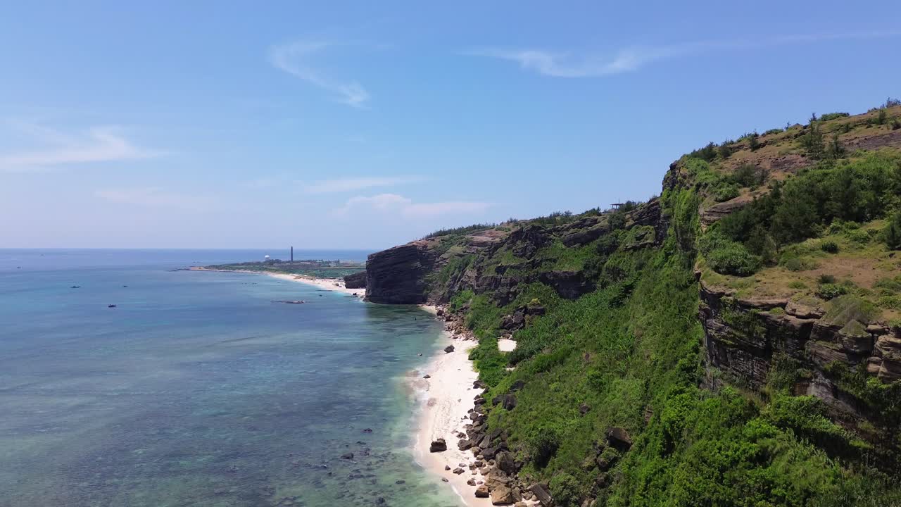 Ascending aerial showing coastal cliffs, beach and volcanic terrain of Ly Son Island under clear daylight