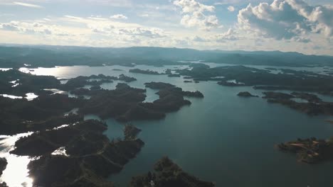 Drone-aerial-view-of-the-lake-and-green-islands-at-El-Peñón-in-Guatapé,-Colombia