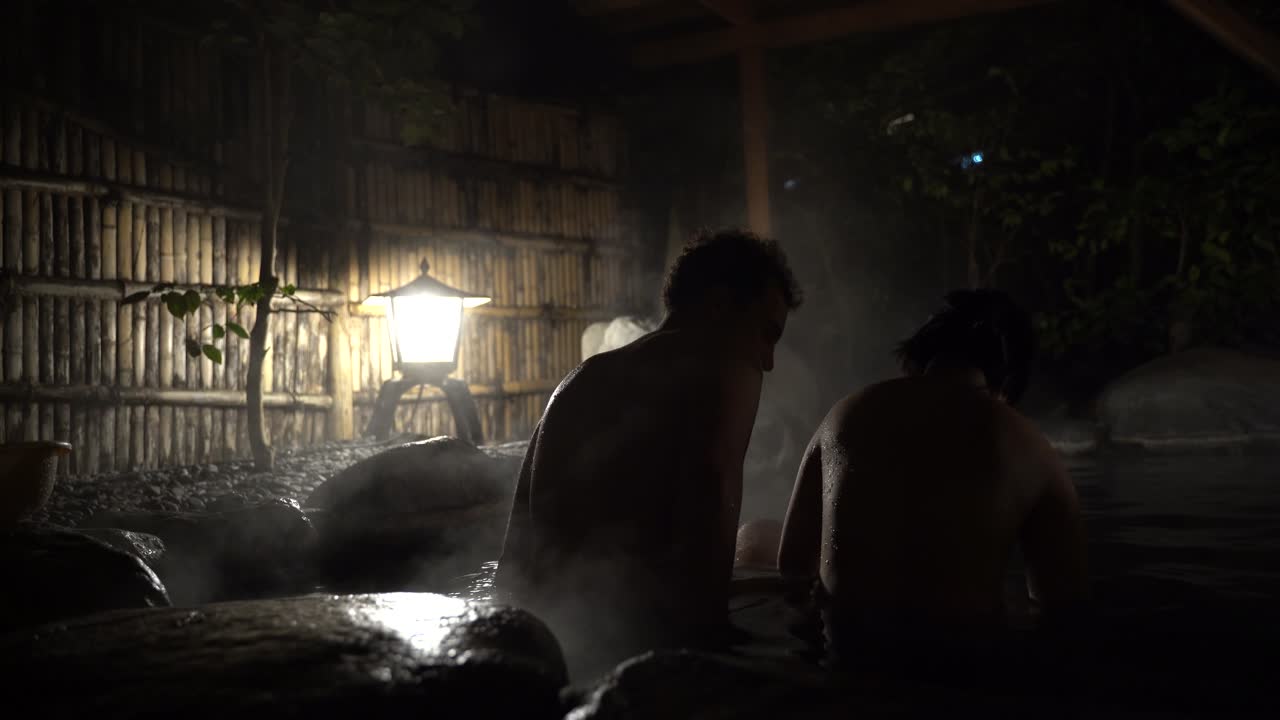 Silhouette Of A Sweet Couple Sitting Inside The Japanese Hot Spring - Close Up Shot