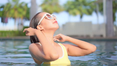 Nahaufnahme-Einer-Jungen-Frau-In-Einem-Swimmingpool,-Die-Ihr-Nasses-Haar-Aus-Ihrem-Gesicht-Glättet