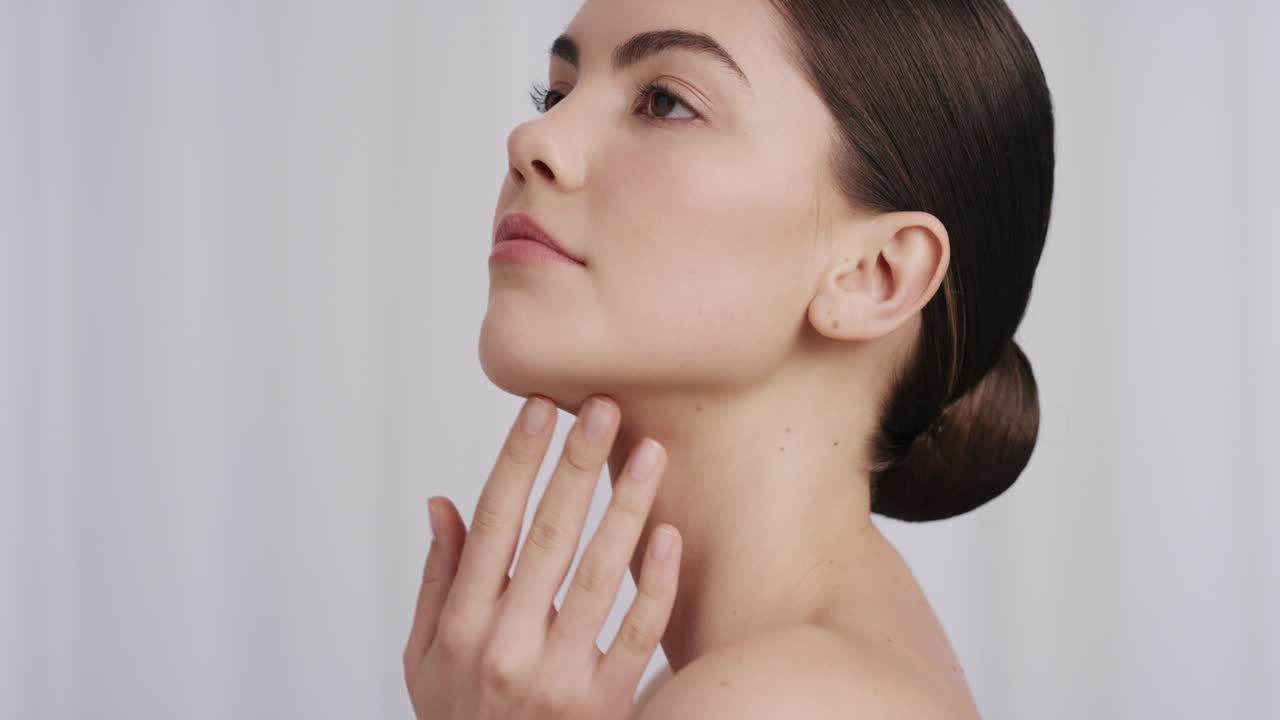 retrato de una mujer joven sana tocando suavemente la piel con las manos acariciando la piel suave y suave hermosa mujer caucásica disfrutando del cuidado de la piel de lujo relajación sensual