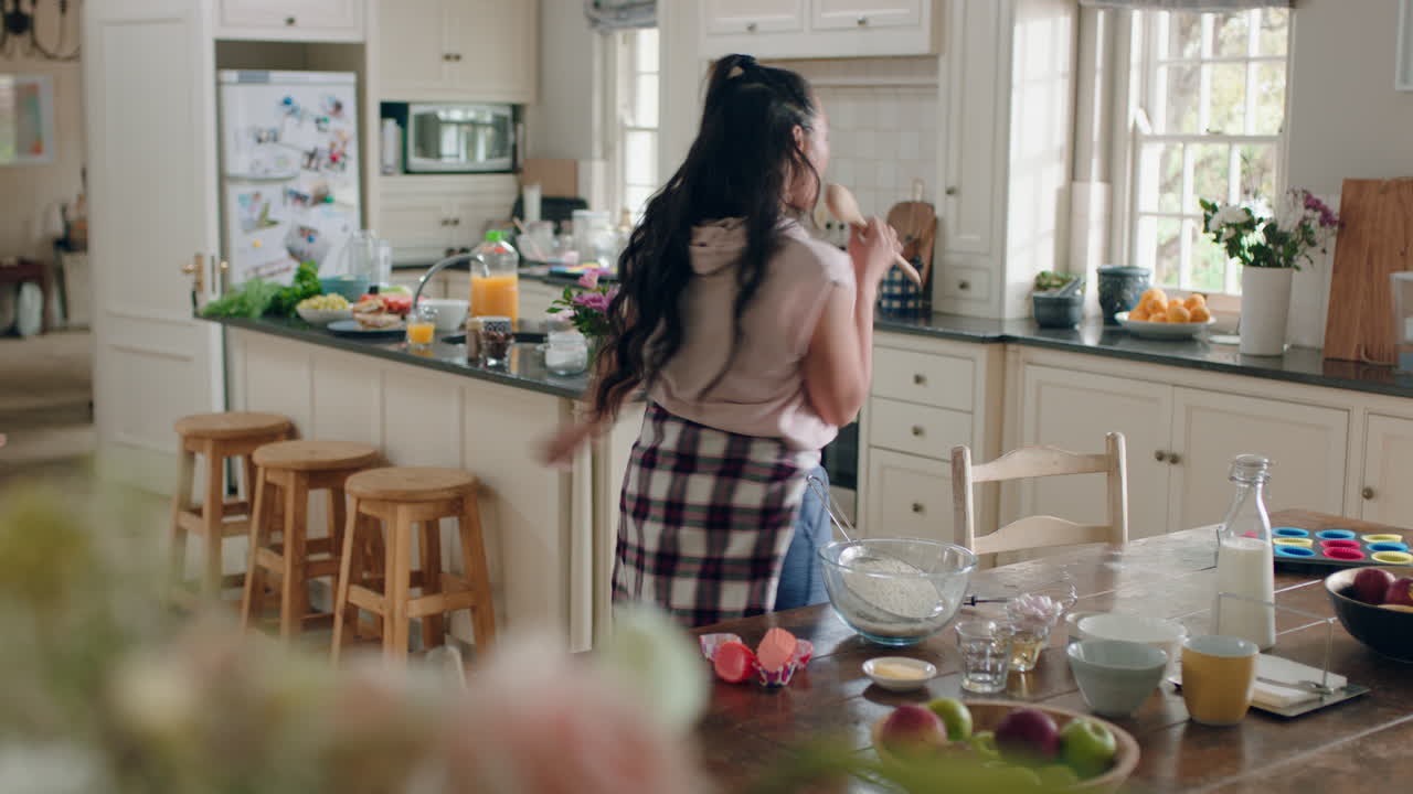 happy overweight teenage girl dancing in kitchen having fun celebrating weekend performing funny dance moves at home enjoying weekend celebration