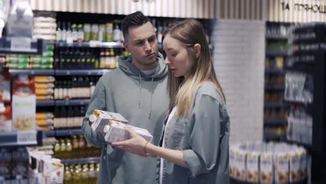 couple in the grocery store. the girl and her boyfriend chooses what she wants to buy. daily