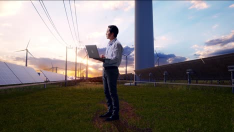 full body side view of an asian male professional worker with solar panel and wind turbines, observes by looking up before he come to concentrating on the laptop and keep on typing