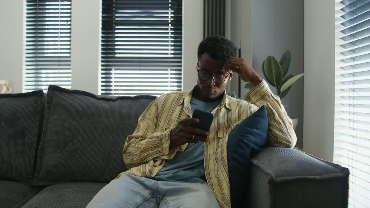 Man using smartphone on couch