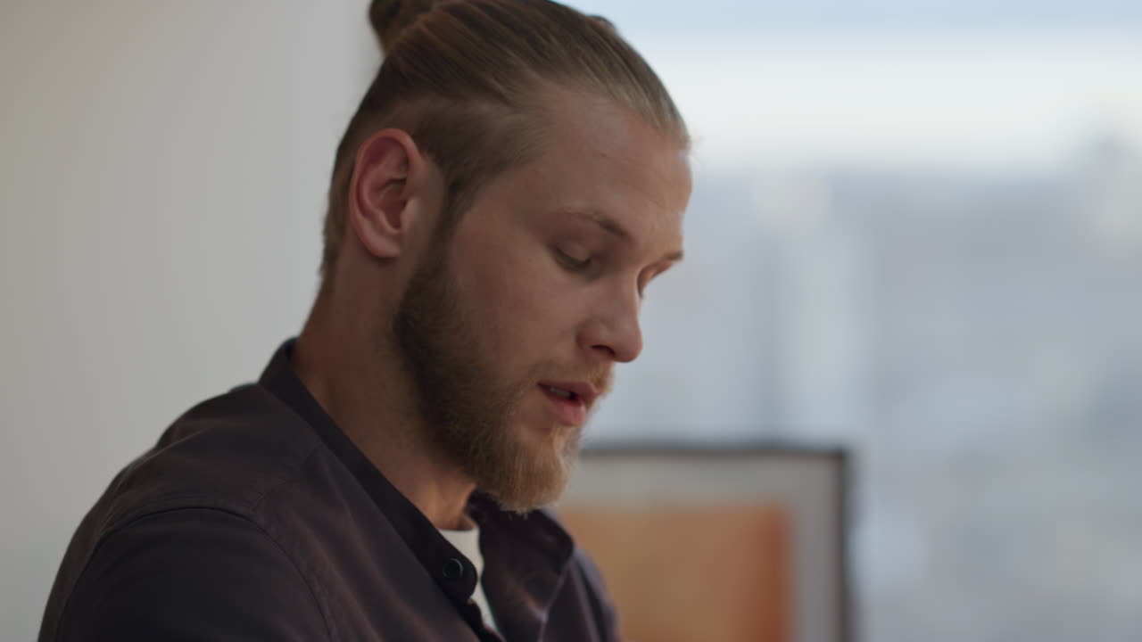 Primo piano di un designer che gesticola parlando in un luogo serale. Uomo scettico che osserva.
