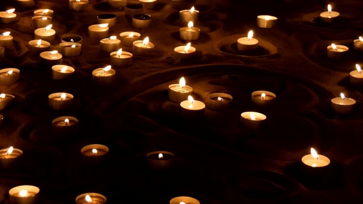 Candele che bruciano nella sabbia
