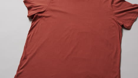video de una capa plana de camiseta naranja con espacio de copia sobre un fondo blanco