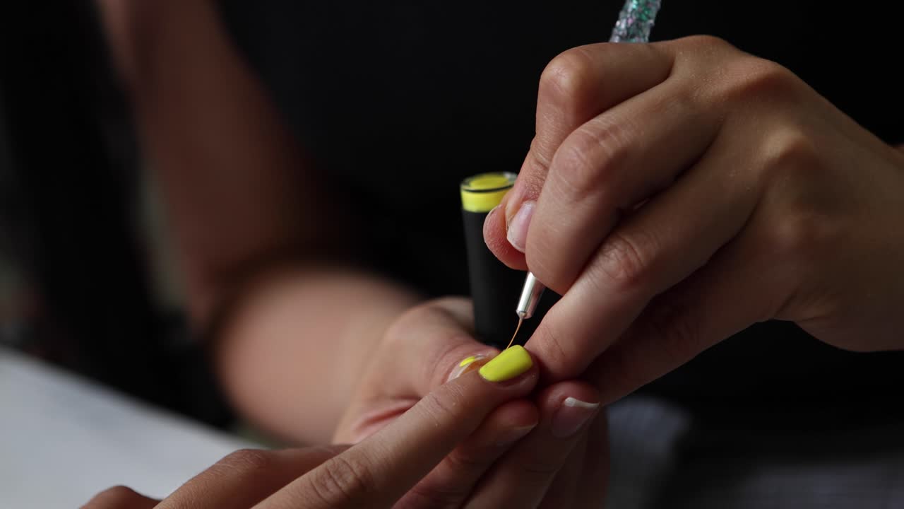 Anonymous ethnic doing manicure to client and applying nail polish