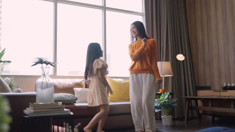 happiness sunday morning mom and daughter spending wonderful moment dancing along together,asian family mother and daughter jump dance cheerful moving together in living room at home