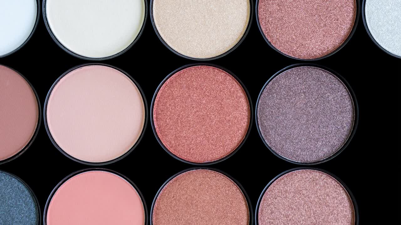 multicolor hermosa paleta de sombra de ojos marrón en fondo negro. aislado. productos de belleza. cosméticos de maquillaje. sombra de ojos de moda, rubor facial. animación de stop motion de colores brillantes. video en bucle.