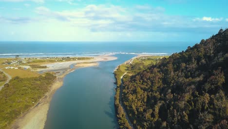 vista de drones desde arriba del río mokihinui y el océano pacífico en nueva zelanda con el suave campamento de annie - dolly shot