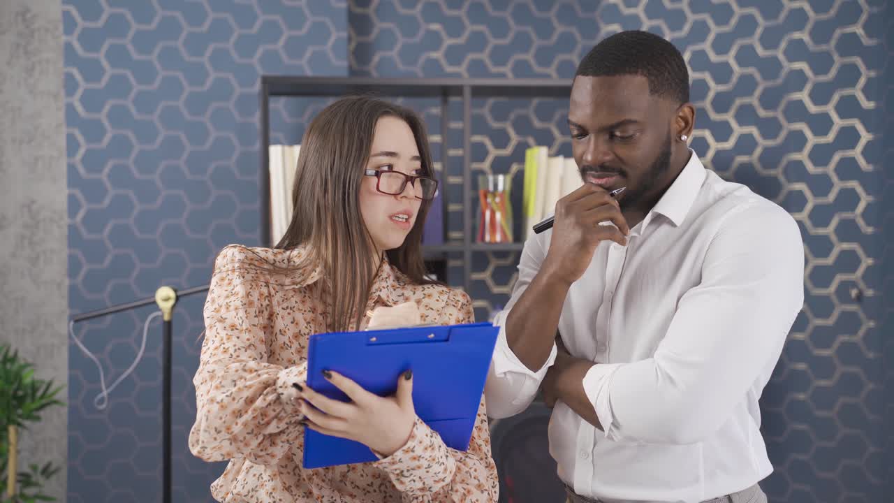 jóvenes compañeros de trabajo multiétnicos felices hablando a través de notas y proyectos.