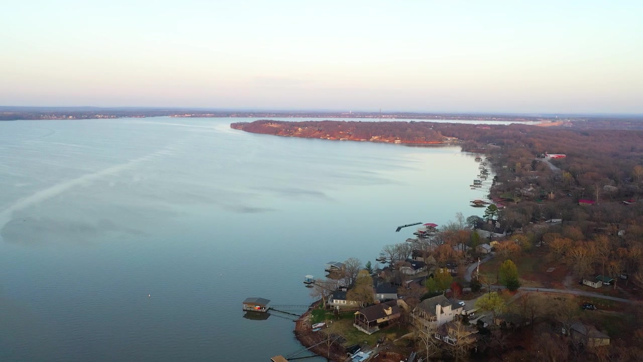 Vista aerea dall'alto del Lago Dale Hollow, Tennessee e Kentucky, che mostra acque calme e blu, case sulla riva, moli privati, insenature boscose e una tranquilla vita lacustre.