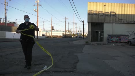 police officer taking down  crime scene tape