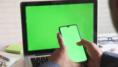 vista trasera de un joven usando un teléfono inteligente en el interior