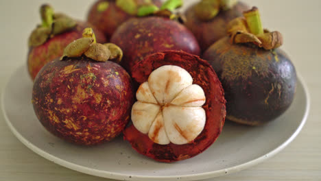 Frutas-Frescas-De-Mangostán-Maduras-En-Un-Plato-Blanco