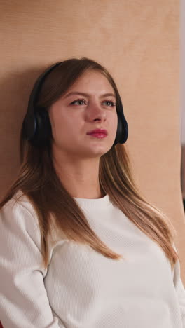 woman with headphones watches video in library. young lady student learns material with digital technology in university. visual information study