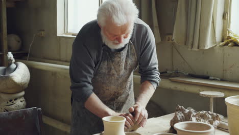 senior potter working on clay in a studio