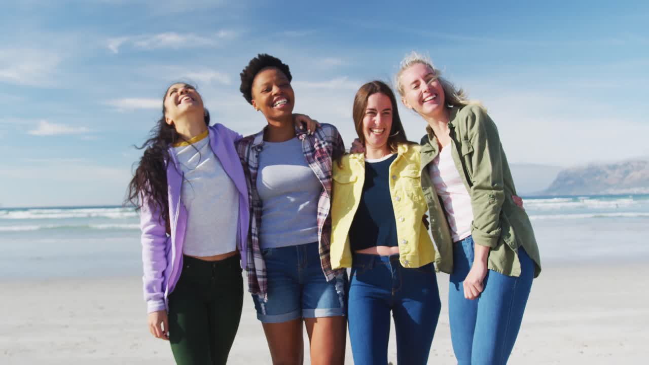 retrato de un grupo feliz de diversas amigas divirtiéndose, riéndose en la playa
