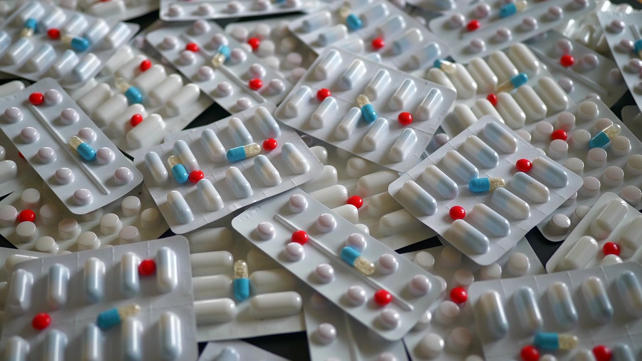 Pila di vari blister farmaceutici su un tavolo