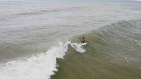 surfista experimentado cabalgando y chocando contra una gran ola de barril, vista aérea de méxico