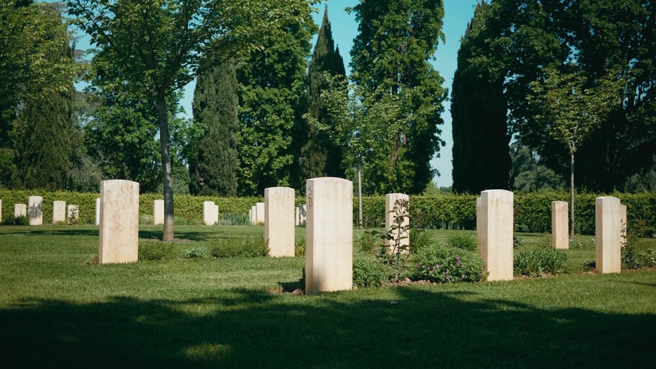 Lapidi illuminate dal sole in un tranquillo parco cimitero.