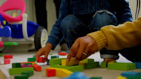 primer plano de una joven familia negra jugando y sentada en el suelo de una casa cómoda 4k